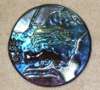 In this view, the piece is seen by reflected light - iridescent glass with a metallic sheen that (depending on the angle to the light source) reflects constantly changing shimmering rainbow hues.- all transparent blues and grays and black.